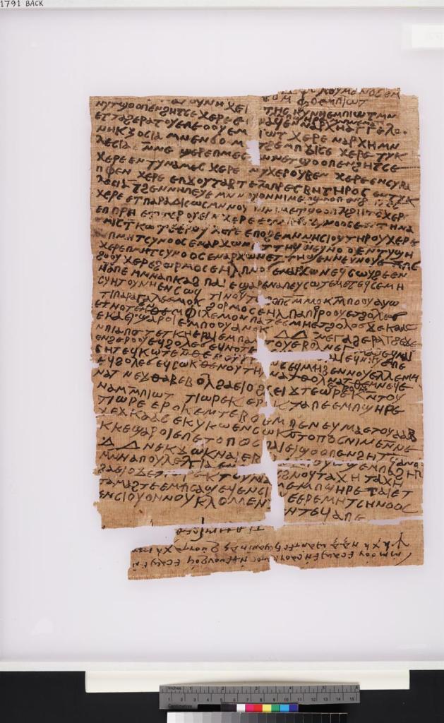 Photograph of a papyrus (red coloured parchment) with Coptic writing on it. 