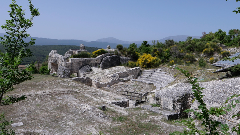 A photograph of archaeological ruins of a Roman city, the theatre of which is prominently featured in the photo. 