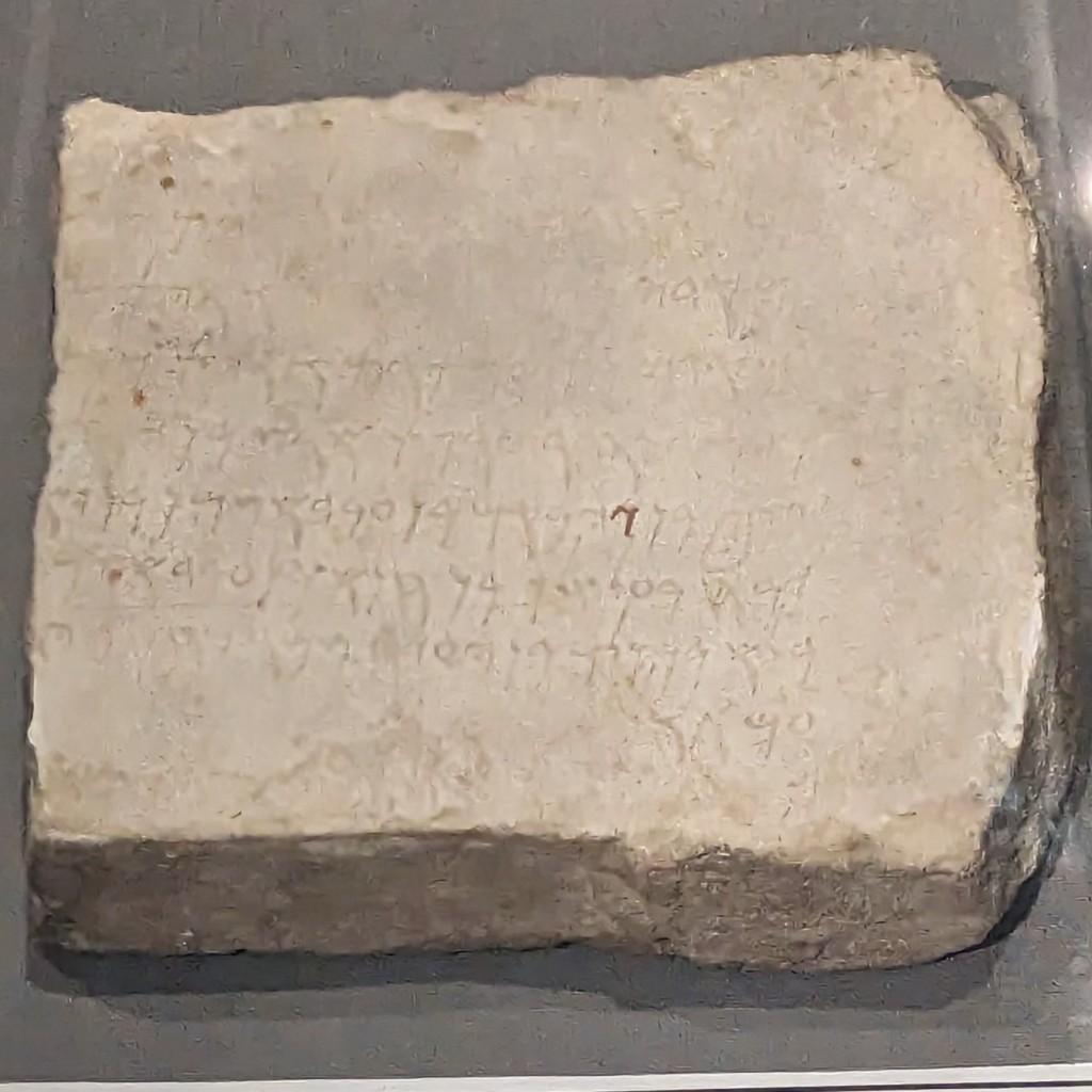 A picture of a white marble tablet with a Punic inscription on it. 